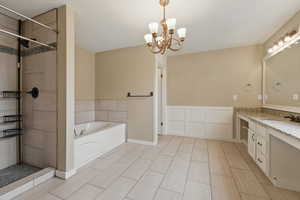 Full bath with vanity, a tile shower, a chandelier, and a bath