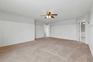 Carpeted spare room with a ceiling fan