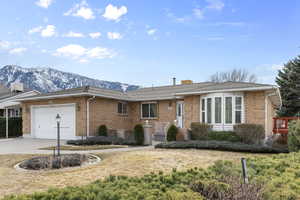 Single story home with a garage and a mountain view
