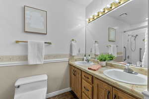 Full bathroom featuring tiled shower / bath combo, vanity, and toilet