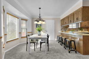Semi-formal dining space featuring ornamental molding and plenty of natural light