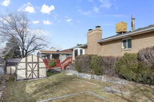 Back of property with a storage shed and a yard
