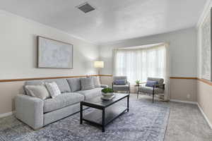 Formal living room with crown molding and a textured ceiling