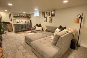 Living room with bar, light carpet, and beverage cooler