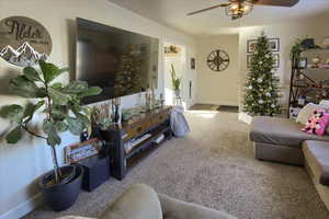 Carpeted living room featuring ceiling fan