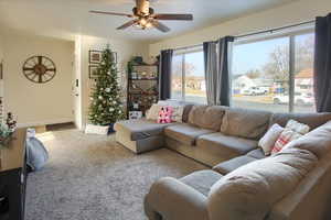 Living room featuring light colored carpet and ceiling fan