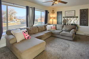 Living room featuring a mountain view, carpet flooring, and ceiling fan