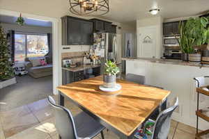 Dining room featuring light tile patterned flooring and a notable chandelier