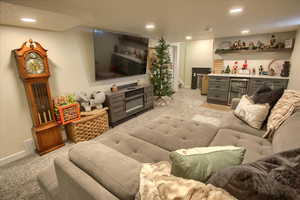 Living room featuring bar, light colored carpet, and beverage cooler