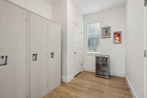 Corridor featuring beverage cooler and light hardwood / wood-style floors