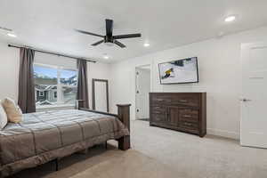 Bedroom with ceiling fan and light colored carpet