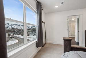 Bedroom featuring carpet, connected bathroom, and a mountain view