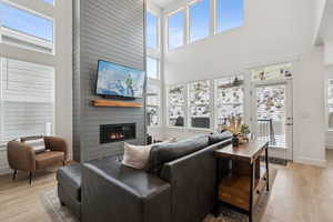 Living room featuring a fireplace, plenty of natural light, and light wood-type flooring