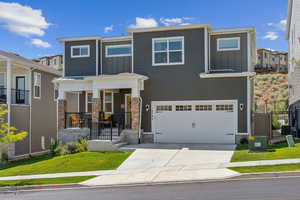 View of front facade featuring a garage, a front lawn, central air condition unit, and covered porch