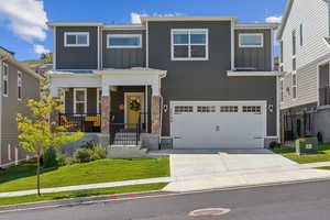 View of front of house featuring a garage, central AC unit, covered porch, and a front yard