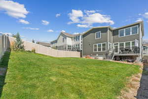 Back of house featuring a yard and a deck