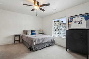 Carpeted bedroom featuring ceiling fan