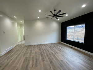 Spare room featuring ceiling fan, lofted ceiling, and light hardwood / wood-style floors