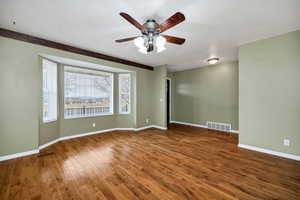 Spare room featuring dark hardwood / wood-style floors and ceiling fan