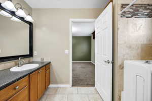 Bathroom featuring vanity, washer / dryer, and tile patterned floors