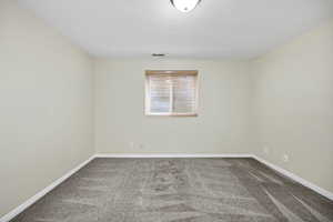 Carpeted empty room with a textured ceiling