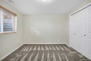 Unfurnished bedroom with carpet flooring and a closet