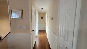 Corridor with hardwood / wood-style floors