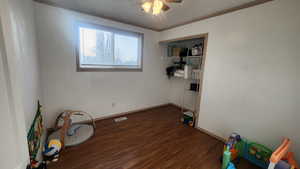 Upstairs bedroom #3 featuring crown molding, dark wood-type flooring, and ceiling fan