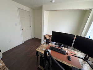 Office area featuring dark hardwood / wood-style floors and a textured ceiling