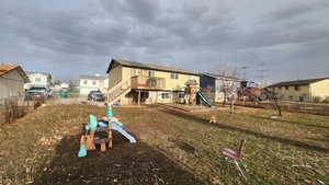 View of jungle gym with a yard and a deck