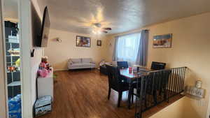 Living room with hardwood / wood-style flooring, ceiling fan, and a textured ceiling