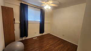 Upstairs bedroom #2 with ceiling fan and dark hardwood / wood-style flooring