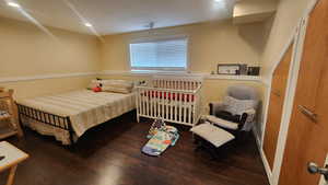 Master Bedroom downstairs with hardwood / wood-style flooring