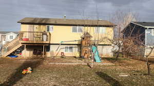 Back of property with a wooden deck and a playground