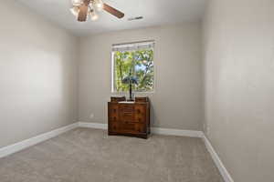 Carpeted spare room featuring ceiling fan