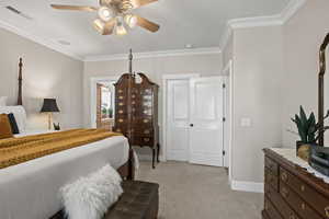 Carpeted bedroom with ornamental molding and ceiling fan