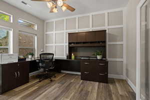 Office area with dark hardwood / wood-style floors and ceiling fan