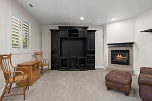 Carpeted living room featuring a tiled fireplace