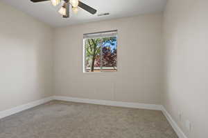 Unfurnished room featuring ceiling fan and carpet flooring