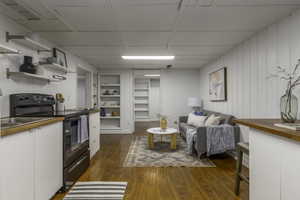 Living room with built in shelves and dark hardwood / wood-style floors