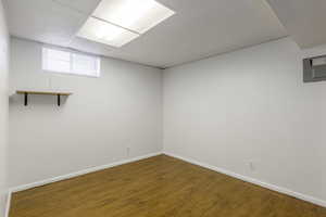 Basement with wood-type flooring and a drop ceiling