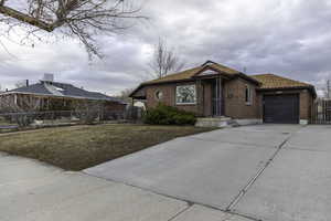 Single story home featuring a garage and a front lawn