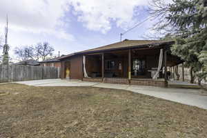 Rear view of house with a patio and a yard