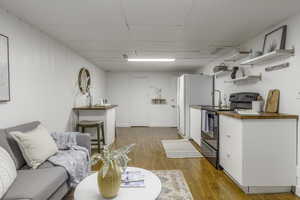 Living room featuring a paneled ceiling and light hardwood / wood-style floors