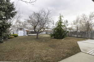 View of yard featuring a storage shed and a patio