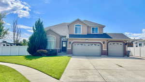 View of front of property featuring a garage and a front yard