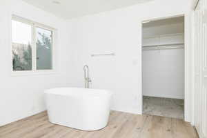 Bathroom with hardwood / wood-style flooring and a bathtub