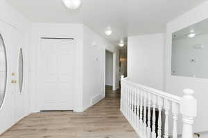 Hallway with light hardwood / wood-style flooring