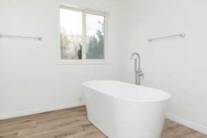 Bathroom with hardwood / wood-style flooring and a tub