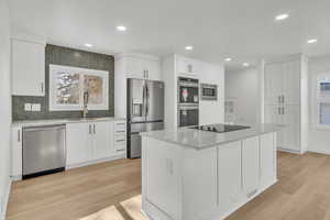 Kitchen with a kitchen island, white cabinets, and appliances with stainless steel finishes